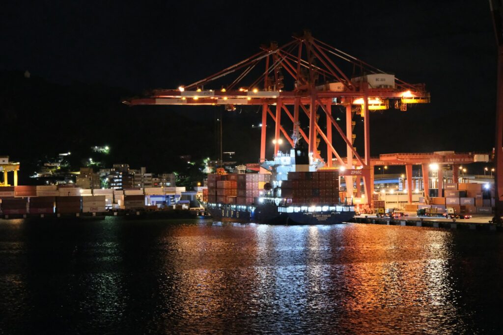 Large industrial cranes at a harbor at night.